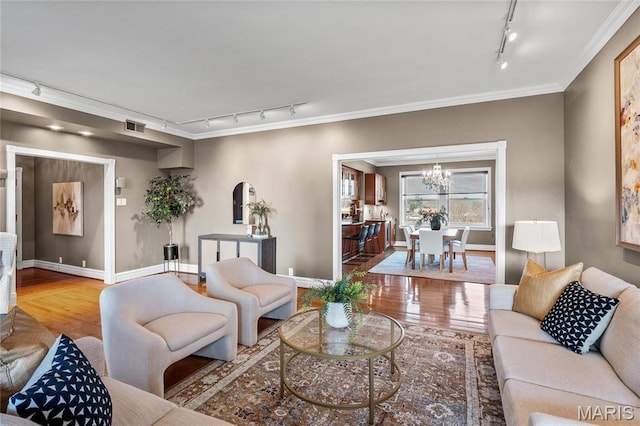 625 S Skinker Blvd Unit 602, Saint Louis, MO 63105 - living room with track lighting, wood finished floors, a chandelier, and crown molding