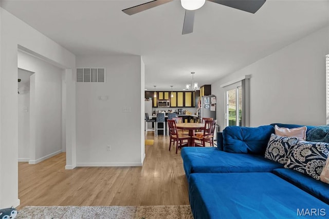 757 Fox Creek Dr, Fenton, MO 63026 - living area with a ceiling fan, light wood-style floors, a chandelier, and baseboards