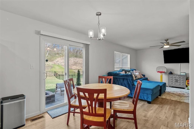 757 Fox Creek Dr, Fenton, MO 63026 - dining room featuring light wood-type flooring, a chandelier, a ceiling fan, and baseboards
