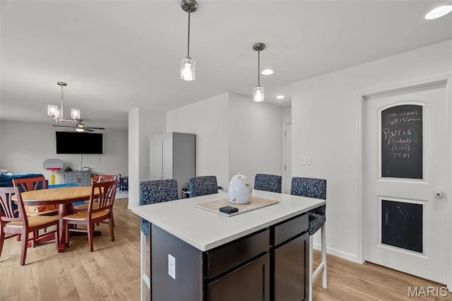 757 Fox Creek Dr, Fenton, MO 63026 - kitchen with a kitchen island, light wood-style flooring, a kitchen bar, pendant lighting, and recessed lighting