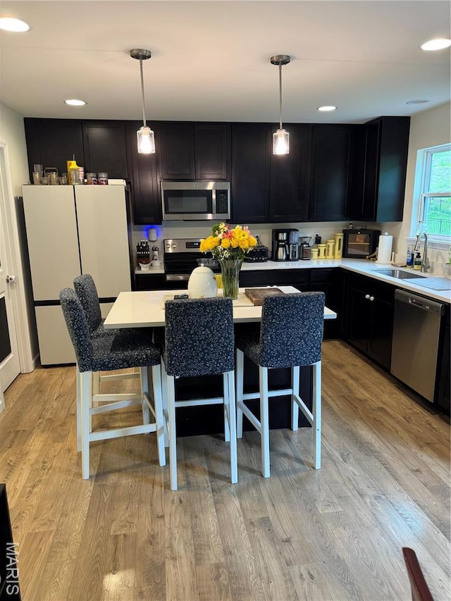 757 Fox Creek Dr, Fenton, MO 63026 - kitchen featuring stainless steel appliances, dark cabinetry, light countertops, a kitchen bar, and recessed lighting