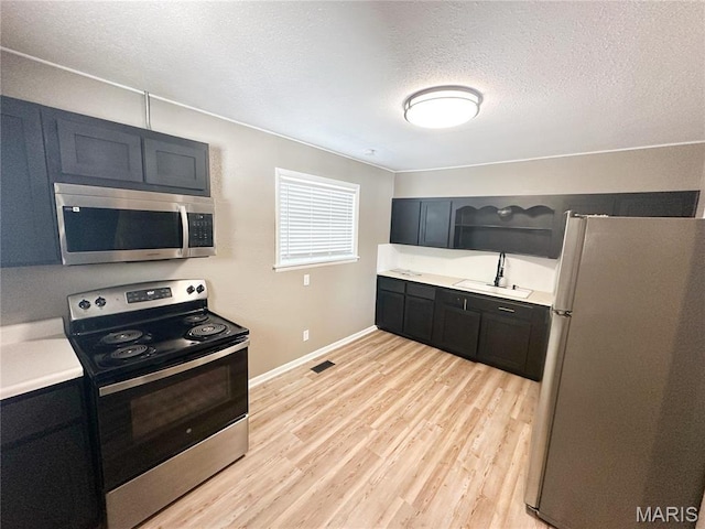 501 N Warfel St, Salem, MO 65560 - kitchen with stainless steel appliances, light wood-style floors, light countertops, a textured ceiling, and open shelves
