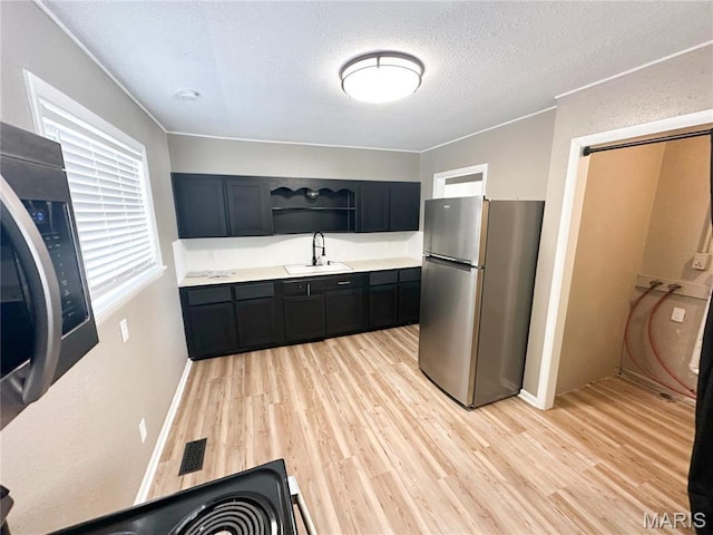 501 N Warfel St, Salem, MO 65560 - kitchen featuring freestanding refrigerator, open shelves, light wood-type flooring, light countertops, and a sink