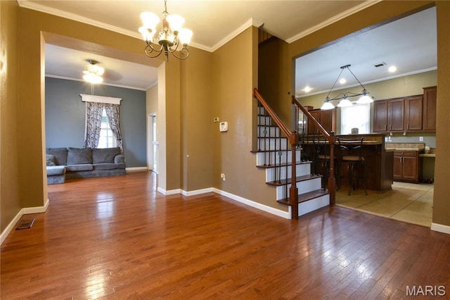 102 W High St, Troy, IL 62294 - foyer featuring light wood-type flooring, a chandelier, stairway, ornamental molding, and baseboards