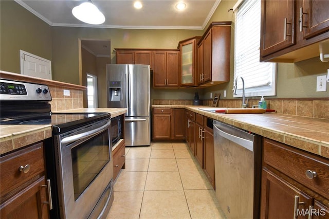 102 W High St, Troy, IL 62294 - kitchen with appliances with stainless steel finishes, a sink, crown molding, glass insert cabinets, and healthy amount of natural light