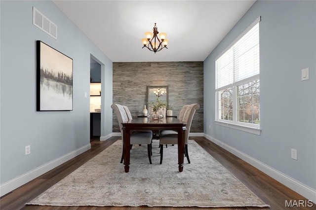 206 Willow Park Ct, Wentzville, MO 63385 - dining space with a chandelier, baseboards, dark wood-style floors, and an accent wall