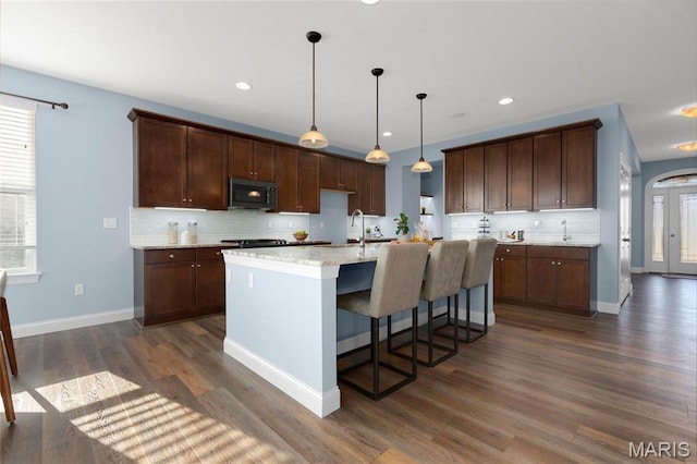 206 Willow Park Ct, Wentzville, MO 63385 - kitchen featuring decorative backsplash, dark wood finished floors, a kitchen island with sink, baseboards, and recessed lighting