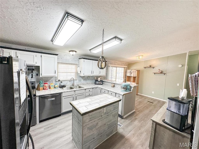 405 County Road 5015, Salem, MO 65560 - kitchen featuring dishwasher, freestanding refrigerator, a peninsula, a textured ceiling, and light wood finished floors