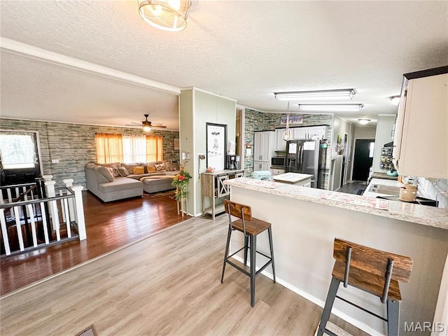 405 County Road 5015, Salem, MO 65560 - kitchen with a peninsula, a textured ceiling, healthy amount of natural light, fridge with ice dispenser, and light wood-style floors