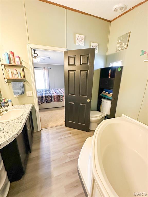 405 County Road 5015, Salem, MO 65560 - ensuite bathroom featuring wood finished floors, vanity, a ceiling fan, ornamental molding, and toilet