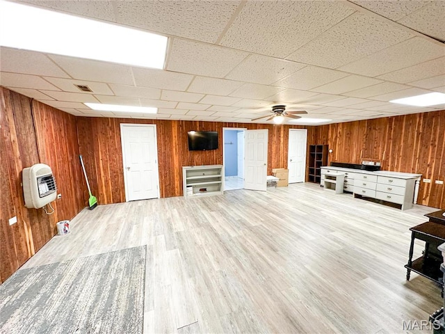 405 County Road 5015, Salem, MO 65560 - unfurnished living room featuring heating unit, wooden walls, a ceiling fan, and light wood-type flooring