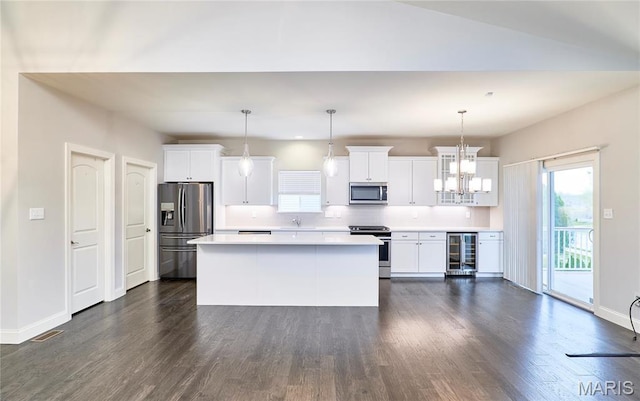 513 Upper Ridgepointe Ct, Lake St Louis, MO 63367 - kitchen featuring appliances with stainless steel finishes, beverage cooler, a kitchen island, dark wood-type flooring, and light countertops