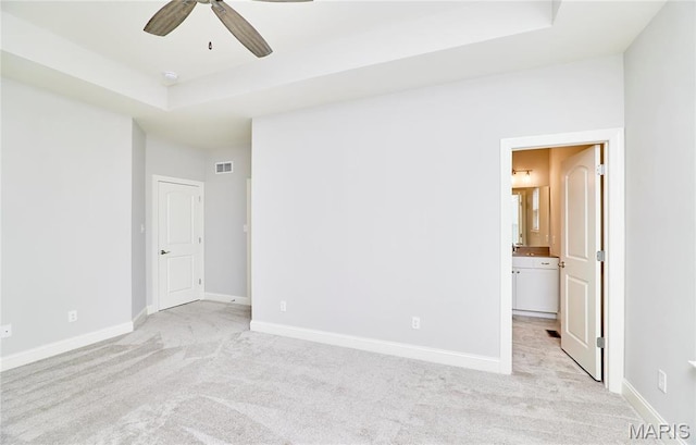 513 Upper Ridgepointe Ct, Lake St Louis, MO 63367 - unfurnished bedroom with a raised ceiling, light colored carpet, baseboards, connected bathroom, and a ceiling fan