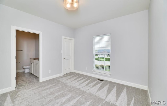 513 Upper Ridgepointe Ct, Lake St Louis, MO 63367 - unfurnished bedroom featuring light colored carpet, baseboards, and connected bathroom