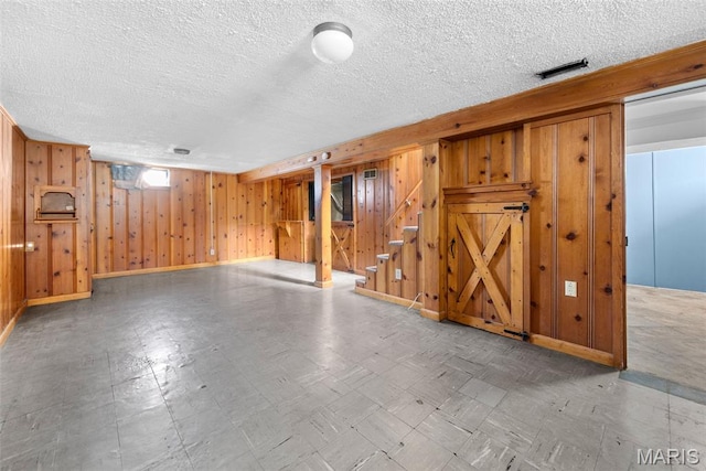 6541 SW Ave, Saint Louis, MO 63139 - basement featuring stairs, wood walls, a textured ceiling, and tile patterned floors