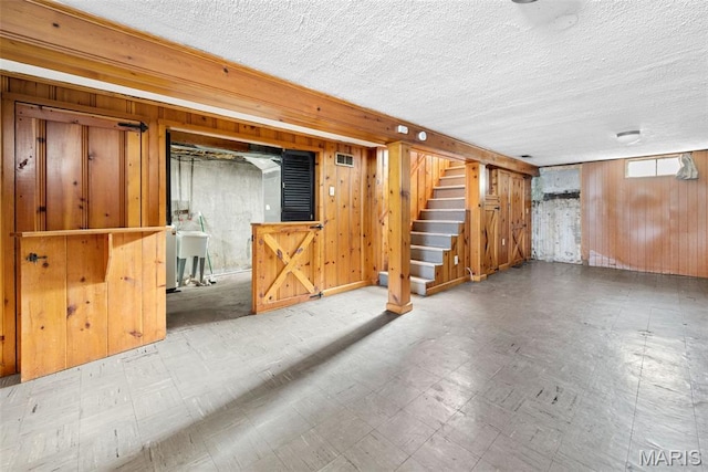 6541 SW Ave, Saint Louis, MO 63139 - below grade area featuring tile patterned floors, wooden walls, stairs, and a textured ceiling