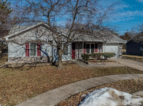 ranch-style home featuring a garage and driveway