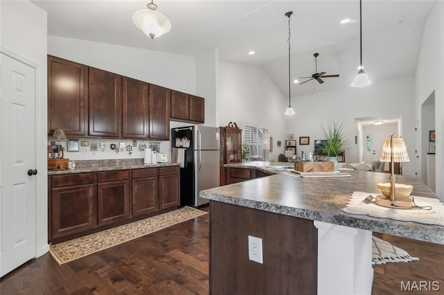 5374 Trailhead Ct, Eureka, MO 63025 - kitchen with freestanding refrigerator, ceiling fan, high vaulted ceiling, a kitchen bar, and dark brown cabinets