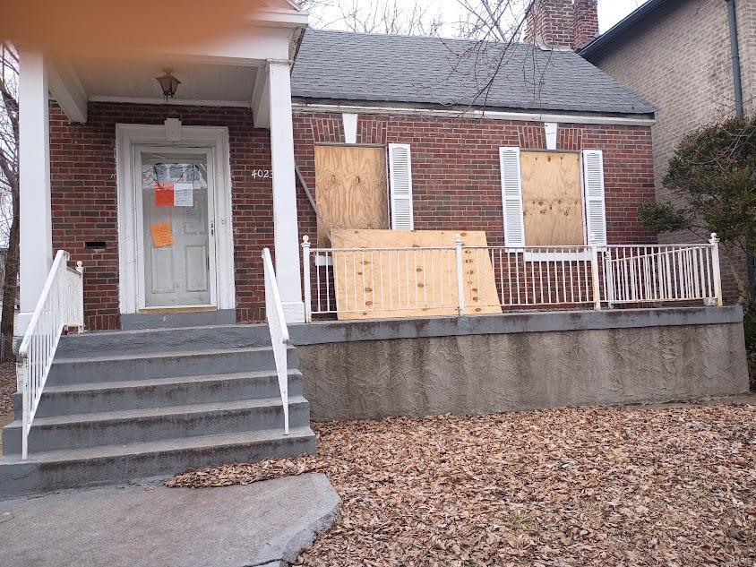 4023 Giles Ave, Saint Louis, MO 63116 - doorway to property featuring brick siding, roof with shingles, and a chimney