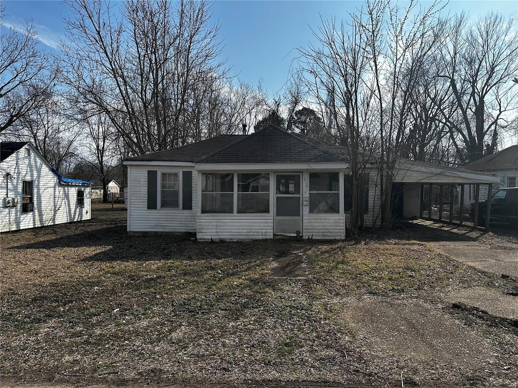 620 Dewey St, Poplar Bluff, MO 63901 - back of house featuring a sunroom, a carport, driveway, and a shingled roof