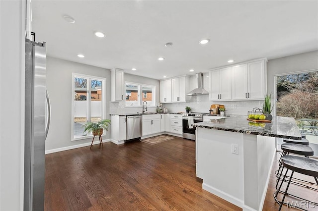 86 Heather View Dr, Chesterfield, MO 63017 - kitchen with wall chimney exhaust hood, a sink, appliances with stainless steel finishes, a peninsula, and backsplash