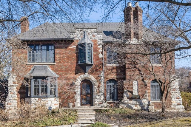 364 Mission Ct, Saint Louis, MO 63130 - view of front of home featuring a chimney, roof with shingles, stone siding, and brick siding