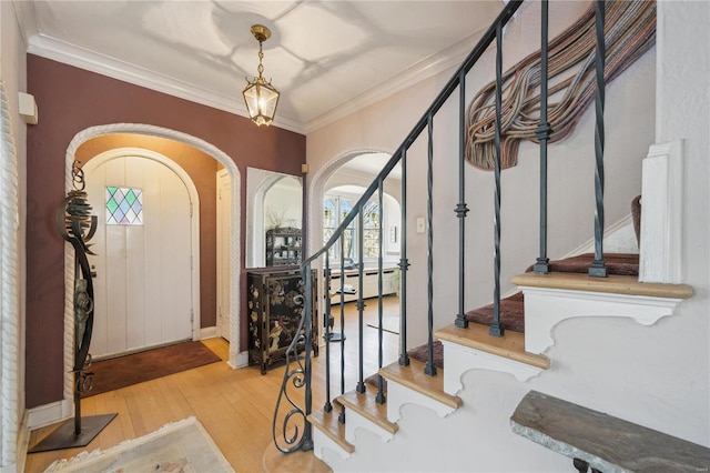364 Mission Ct, Saint Louis, MO 63130 - entrance foyer with arched walkways, stairs, wood finished floors, and crown molding