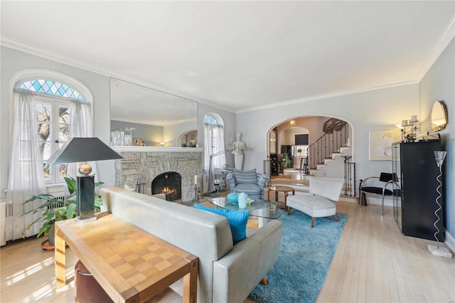 364 Mission Ct, Saint Louis, MO 63130 - living room featuring a fireplace, stairs, arched walkways, crown molding, and wood finished floors