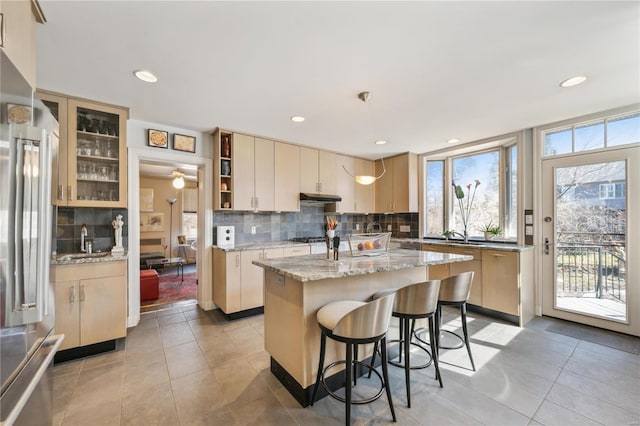 364 Mission Ct, Saint Louis, MO 63130 - kitchen with tasteful backsplash, a center island, stainless steel appliances, light stone countertops, and light tile patterned floors
