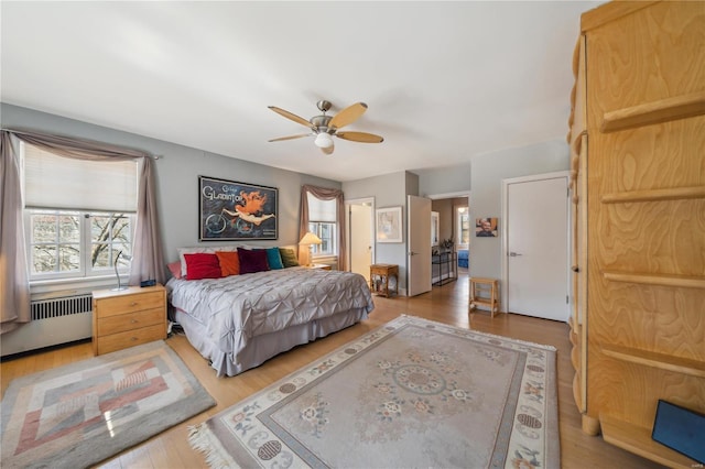 364 Mission Ct, Saint Louis, MO 63130 - bedroom featuring radiator heating unit, light wood-style floors, and a ceiling fan