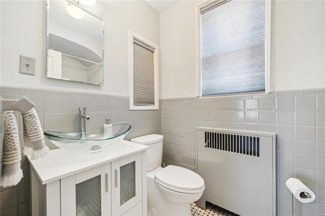 364 Mission Ct, Saint Louis, MO 63130 - bathroom with radiator, tile walls, toilet, a wainscoted wall, and vanity