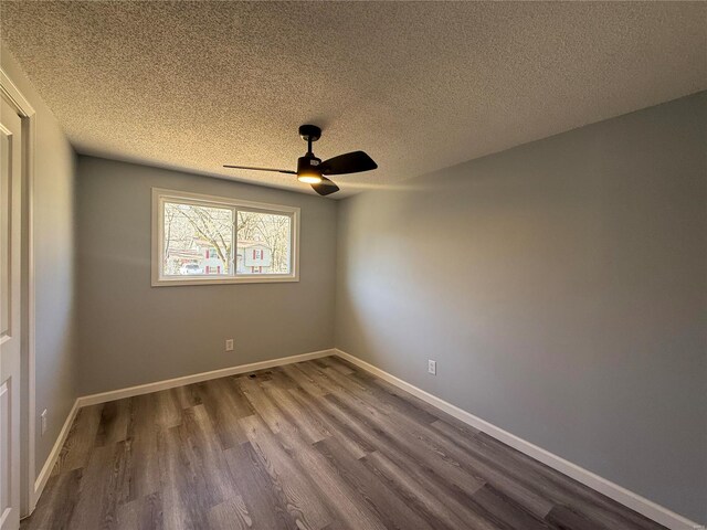 6043 Parkedge Dr, House Springs, MO 63051 - unfurnished room with dark wood-style floors, a ceiling fan, a textured ceiling, and baseboards