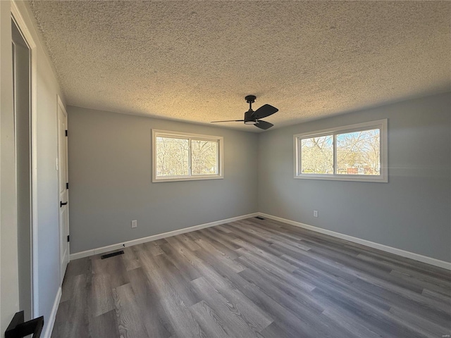 6043 Parkedge Dr, House Springs, MO 63051 - empty room with a textured ceiling, healthy amount of natural light, dark wood-style floors, ceiling fan, and baseboards