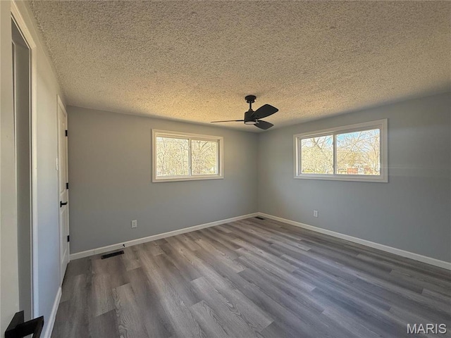 6043 Parkedge Dr, House Springs, MO 63051 - empty room with a textured ceiling, plenty of natural light, wood finished floors, and ceiling fan