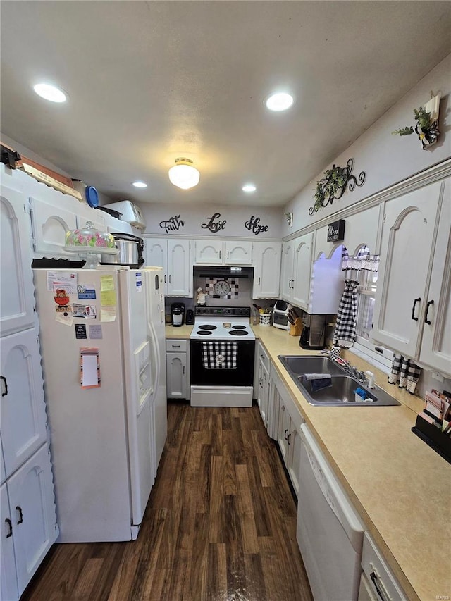 kitchen with white appliances, a sink, dark wood finished floors, light countertops, and recessed lighting