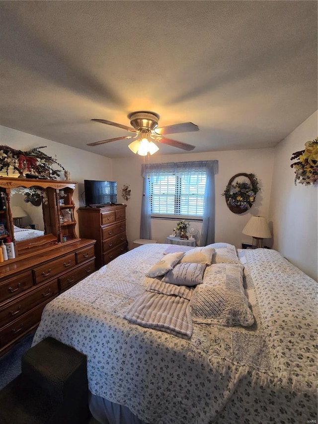 bedroom with a ceiling fan and a textured ceiling