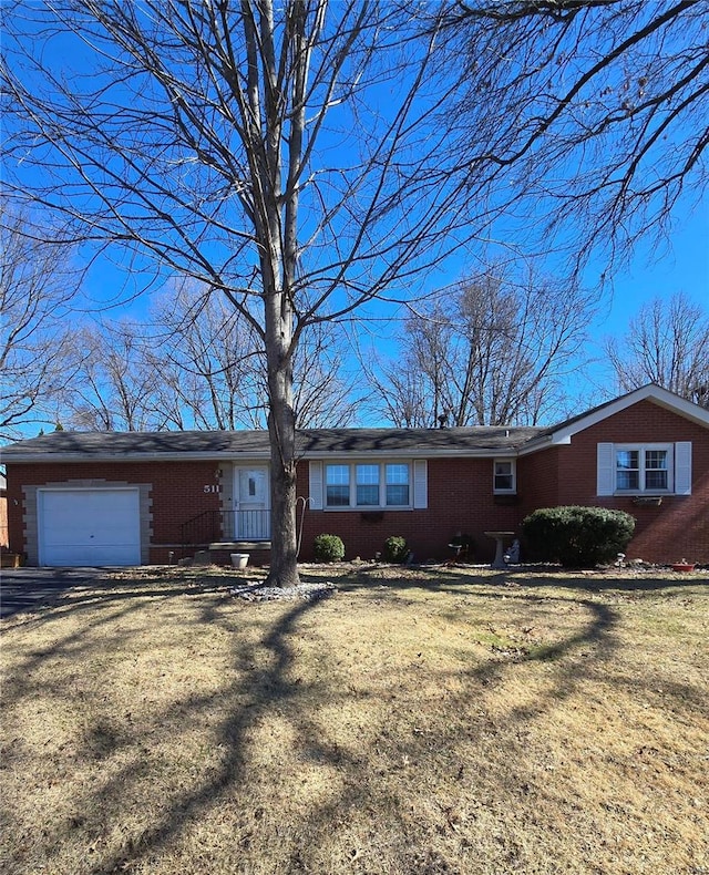 single story home with a garage, brick siding, and a front yard