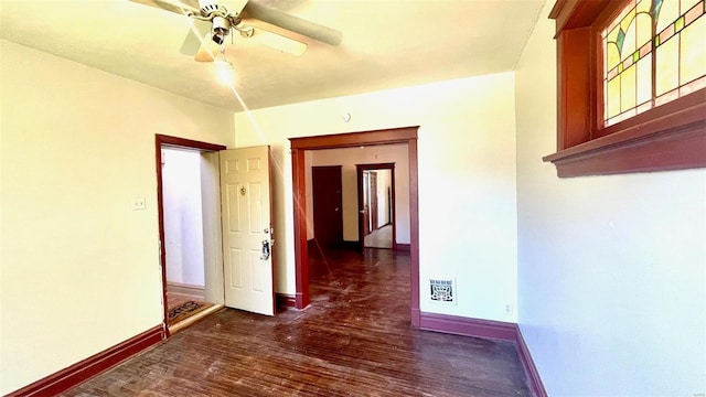 empty room featuring ceiling fan, wood finished floors, and baseboards