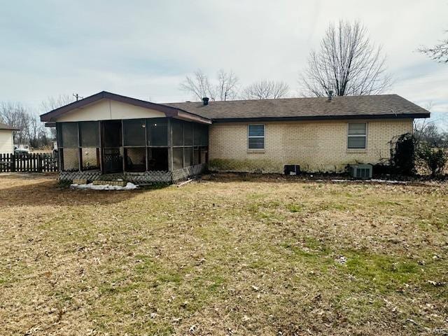 247 Harrison Ln, Poplar Bluff, MO 63901 - back of house featuring a sunroom, cooling unit, brick siding, and a yard