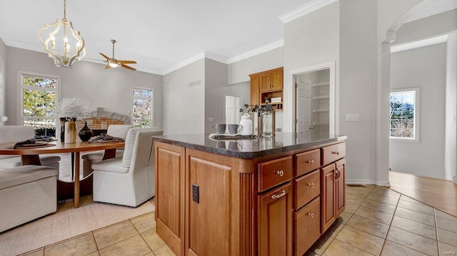 kitchen featuring light tile patterned floors, a chandelier, plenty of natural light, and crown molding