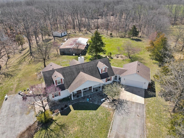 aerial view of property and surrounding area featuring a heavily wooded area