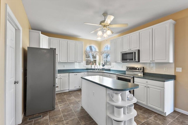 775 Vista Glen Ct, Eureka, MO 63025 - kitchen with appliances with stainless steel finishes, open shelves, a sink, dark countertops, and decorative backsplash
