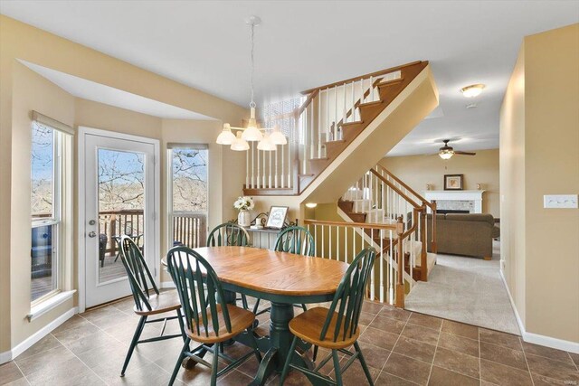 775 Vista Glen Ct, Eureka, MO 63025 - dining room with a fireplace, stairway, a ceiling fan, baseboards, and a chandelier