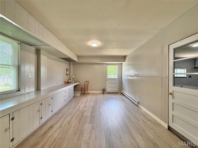 kitchen with a baseboard radiator, light wood-style flooring, white cabinetry, wainscoting, and light countertops