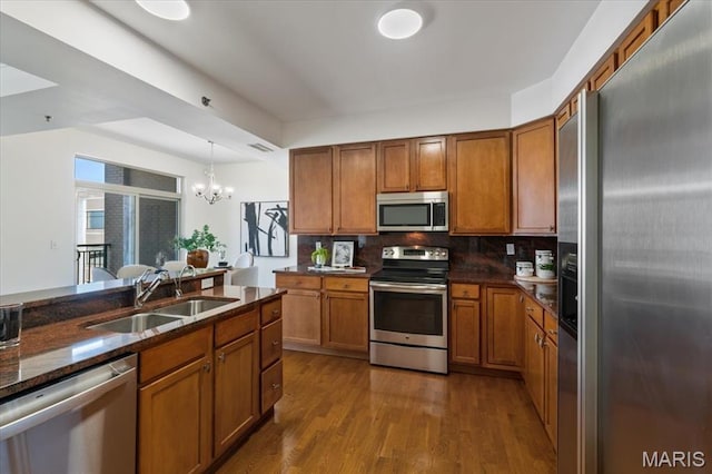 842 N New Ballas Ct Unit 303, Saint Louis, MO 63141 - kitchen featuring appliances with stainless steel finishes, a sink, brown cabinetry, and a chandelier