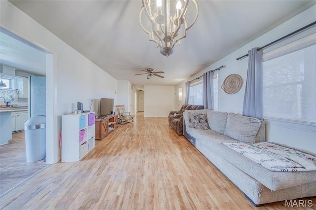 611 N Charles Ave, St James, MO 65559 - living room featuring light wood-style flooring, a chandelier, and healthy amount of natural light