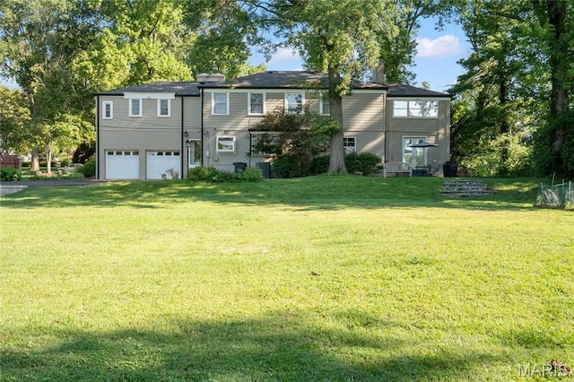 view of front of property featuring an attached garage, a front yard, and driveway