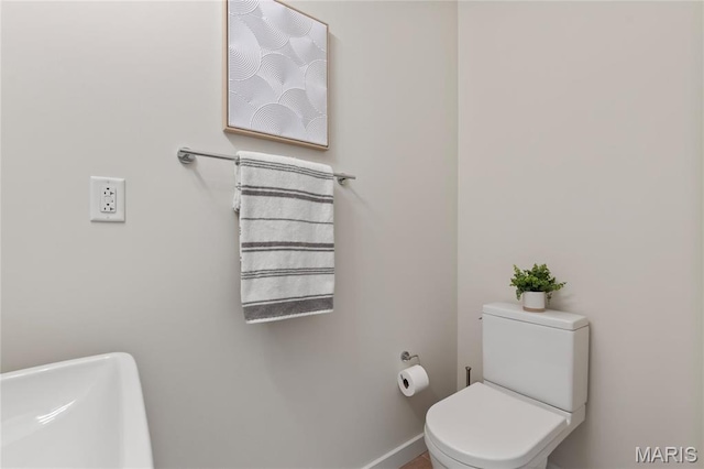bathroom with toilet and baseboards