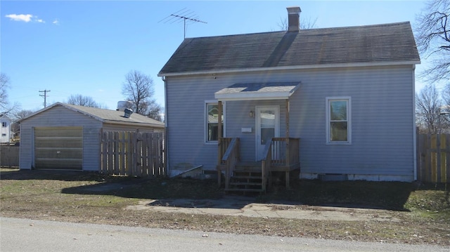 304 W 3rd St S, Mount Olive, IL 62069 - view of front of property featuring fence, a garage, an outbuilding, and a chimney