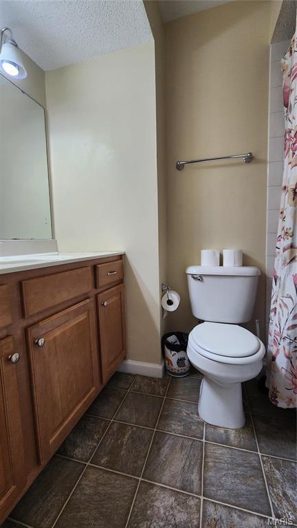 1147 Rue La Chelle Unit 1147, Creve Coeur, MO 63141 - full bath with vanity, toilet, a textured ceiling, tile patterned flooring, and baseboards